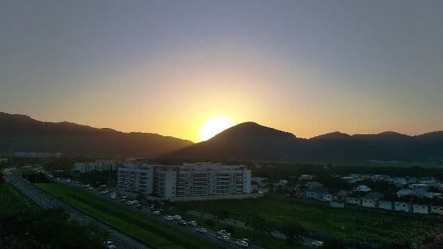 eSuítes Hotel Recreio Shopping e a vista das montanhas com o sol se pondo ao fundo