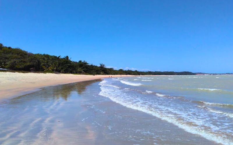 Praia de areia branca, mar de águas quentes.