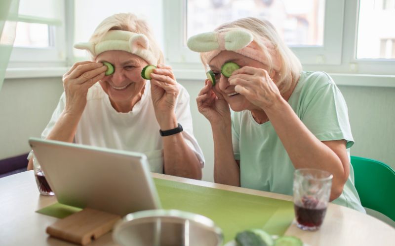 Duas mulheres se divertindo e colocando pepino nos olhos