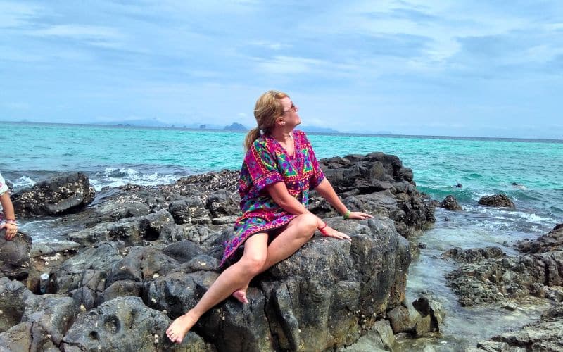 Olivia em cima de uma pedra numa praia em Phi Phi, na Tailândia.