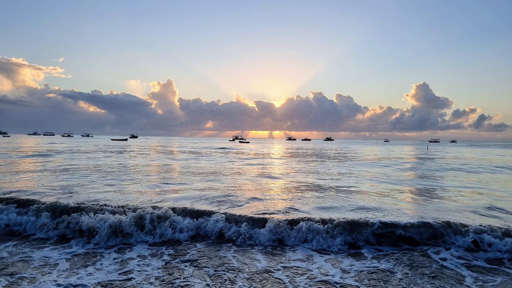 Amanhecer com os seus barquinhos na Praia de Cumuruxatiba no sul da Bahia, nordeste do Brasil